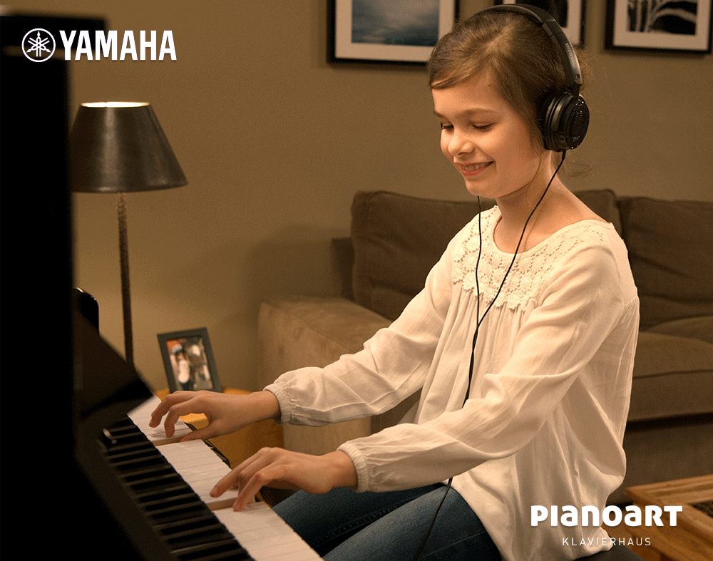 Kind spielt auf einem Yamaha Silent Klavier mit Kopfhörer