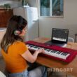 Frau übt auf einem Roland Go Keys 3 Keyboard
