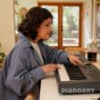 Frau spielt auf Roland Go keys 5 Keyboard